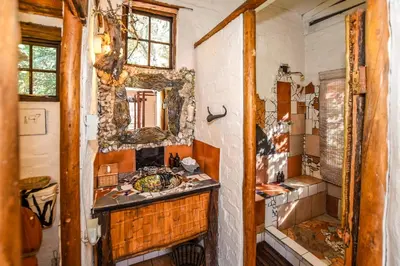 a bathroom with a sink and a mirror at Eloff Guest House and Gallery in White River