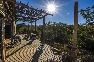 a person walking on a deck with the sun shining at Eloff Guest House and Gallery in White River