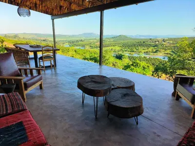 a room with two tables and chairs and a view at Eloff Guest House and Gallery in White River