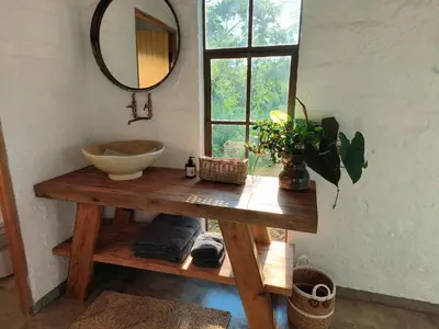 a bathroom with a sink and a mirror on a table at Eloff Guest House and Gallery in White River