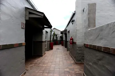 an alley between two buildings with a red fire hydrant at Villa Paradiso in Hartbeespoort