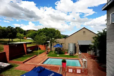 a backyard with a swimming pool and a house at Villa Paradiso in Hartbeespoort