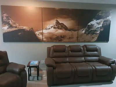 a living room with a couch and a picture on the wall at Fa'Trez Guest House & Spa in Pretoria