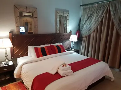 a bedroom with a large bed with towels on it at Fa'Trez Guest House & Spa in Pretoria