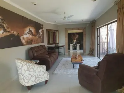 a living room with two couches and a table at Fa'Trez Guest House & Spa in Pretoria