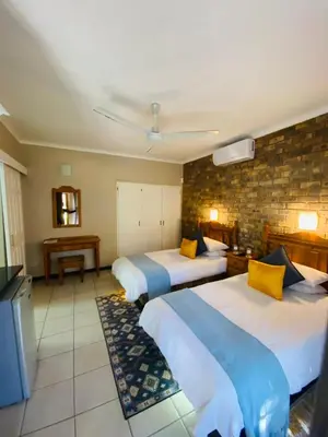 a hotel room with two beds and a piano at Shingalana Guest Lodge in Hazyview
