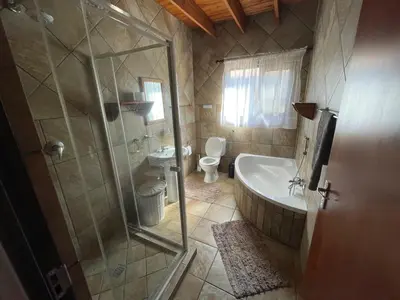 a bathroom with a shower and a tub and a toilet at Nghala Self-catering Holiday Home in Marloth Park
