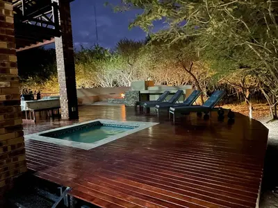 a pool on a deck with chairs and a table at Nghala Self-catering Holiday Home in Marloth Park
