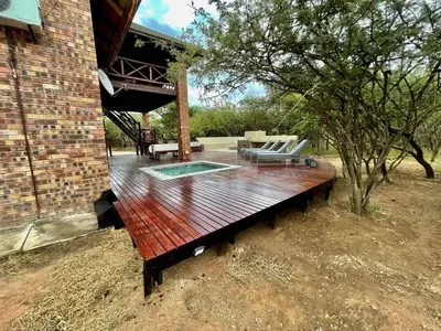 a wooden bench sitting outside of a house at Nghala Self-catering Holiday Home in Marloth Park