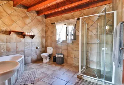 a bathroom with a glass shower and a toilet at Nghala Self-catering Holiday Home in Marloth Park