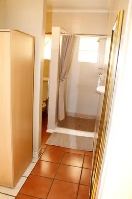 a bathroom with a shower and a sink at Kalahari Guest House in Witbank