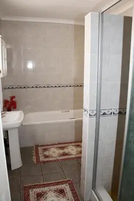 a bathroom with a tub and a toilet and a sink at Kalahari Guest House in Witbank