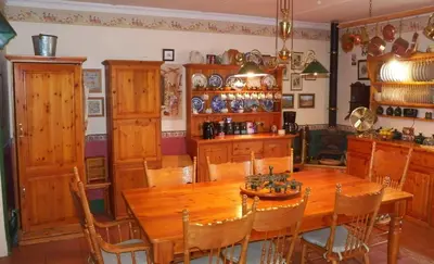 a dining room with a wooden table and chairs at A Pilgrims Rest Guest House in Graskop in Graskop