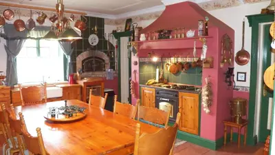 a dining room with a table and a kitchen at A Pilgrims Rest Guest House in Graskop in Graskop