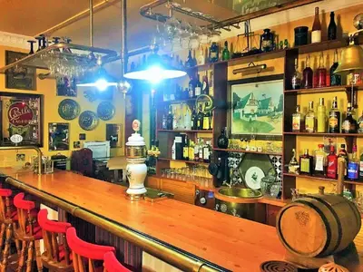 a bar with a wooden counter and red chairs at A Pilgrims Rest Guest House in Graskop in Graskop