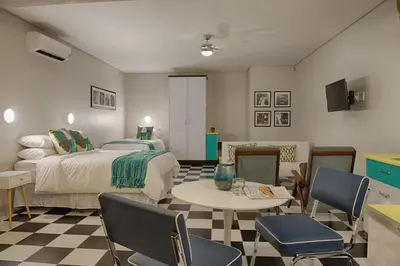 a bedroom with a bed and a table and chairs at HP Twelve Accommodation in Nelspruit