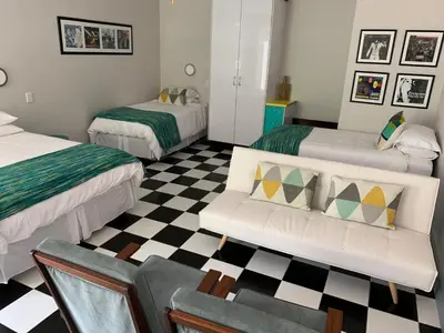 a living room with two beds and a couch at HP Twelve Accommodation in Nelspruit
