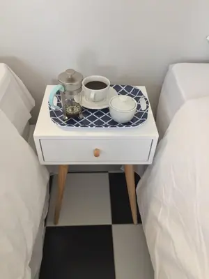 a bedside table with two cups on it next to a bed at HP Twelve Accommodation in Nelspruit