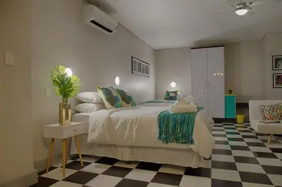 a bedroom with a bed and a checkered floor at HP Twelve Accommodation in Nelspruit