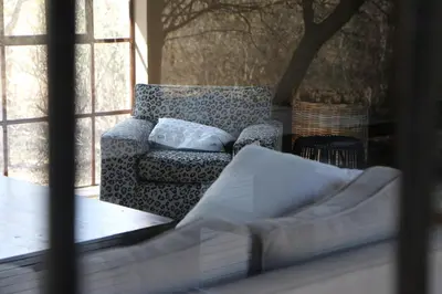 a living room with a couch and a window at Villa ZaZu in Marloth Park