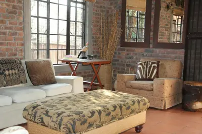 a living room with two chairs and a table at Villa ZaZu in Marloth Park