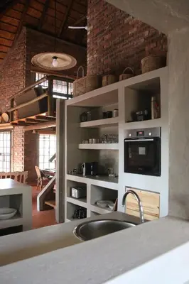 a kitchen with a sink and a brick wall at Villa ZaZu in Marloth Park