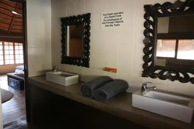 a bathroom with two sinks and a mirror at Villa ZaZu in Marloth Park