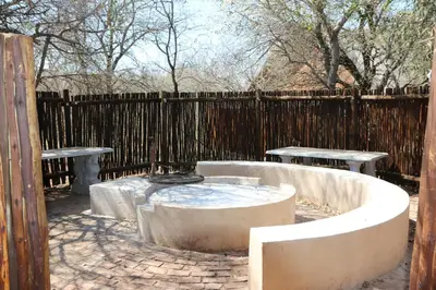 a hot tub in a backyard with two tables and a fence at Villa ZaZu in Marloth Park
