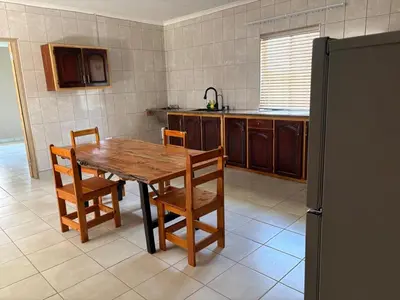 a kitchen with a wooden table and some chairs at Witgatboom Boskamp in Naboomspruit