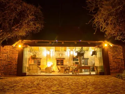 a stone house with lights on it at night at Witgatboom Boskamp in Naboomspruit