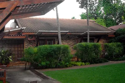 a brick house with a green yard in front of it at Tamboti House in Malelane