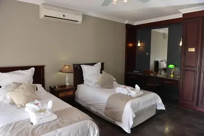 a hotel room with two beds with towels on them at Cornerstone Guest Lodge in Pretoria
