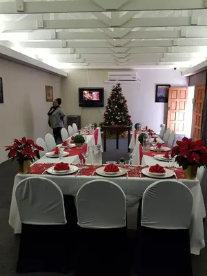 a long table with white chairs and a christmas tree at Cornerstone Guest Lodge in Pretoria