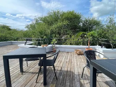 a balcony with a table and chairs on a deck at Switsongo B&B in Hoedspruit