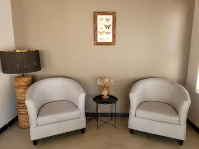 two chairs in a room with a lamp and a table at Switsongo B&B in Hoedspruit