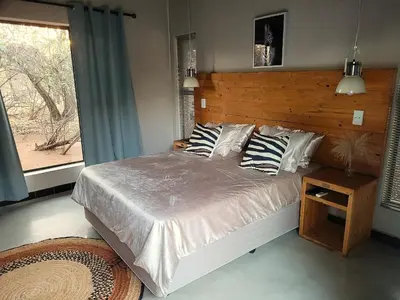 a bedroom with a large bed and a window at Switsongo B&B in Hoedspruit