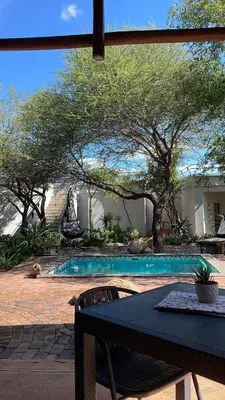a table and chairs next to a swimming pool at Switsongo B&B in Hoedspruit