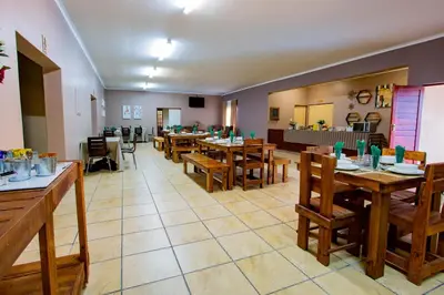 a dining room with wooden tables and chairs at Tambati Overnight and Conference Center in Polokwane