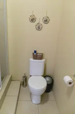 a bathroom with a white toilet in a room at Tambati Overnight and Conference Center in Polokwane