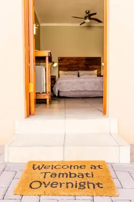 a welcome mat in front of a bedroom with a bed at Tambati Overnight and Conference Center in Polokwane