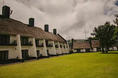 an old building with a grass yard in front of it at Mount Sheba Rainforest Hotel - Mountain Spring Water in Pilgrimʼs Rest