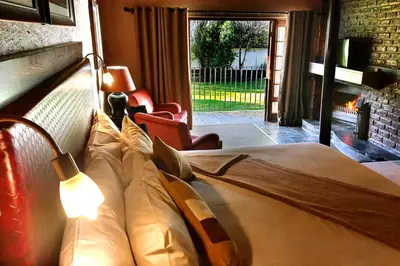 a bedroom with a bed and a fireplace at Mount Sheba Rainforest Hotel - Mountain Spring Water in Pilgrimʼs Rest