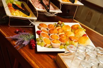 a plate of muffins and fruit on a table at Mount Sheba Rainforest Hotel - Mountain Spring Water in Pilgrimʼs Rest