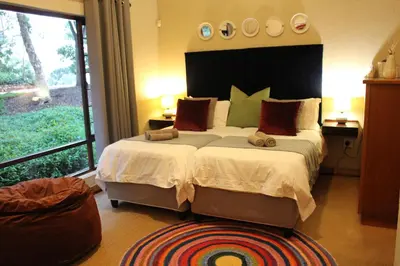 a bedroom with a large bed with a large window at Ulwazi Rock Lodge in Hazyview
