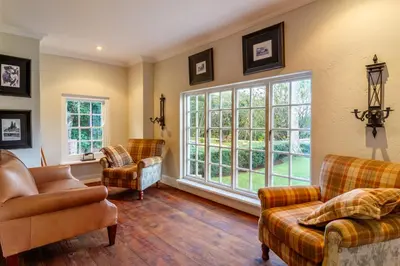 a living room with furniture and a large window at Serra Azul Lodge in Hazyview