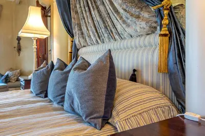 a bed with pillows on it in a room at Serra Azul Lodge in Hazyview