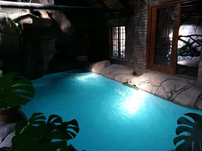 a swimming pool in a house with blue water at Pride Rock Accommodation in Middelburg