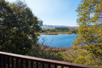 a view of a lake from a wooden bench at Valley of the Rainbow Fly Fishing Estate in Dullstroom