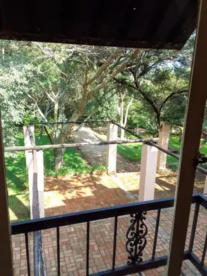 a view from a porch with a fence and trees at Valley of the Rainbow Fly Fishing Estate in Dullstroom