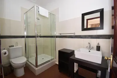 a bathroom with a shower and a toilet and a sink at Cuckoos Nest Guest House in Louis Trichardt